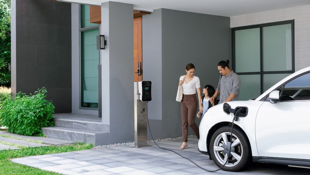 famille qui recharge leur voiture électrique chez eux